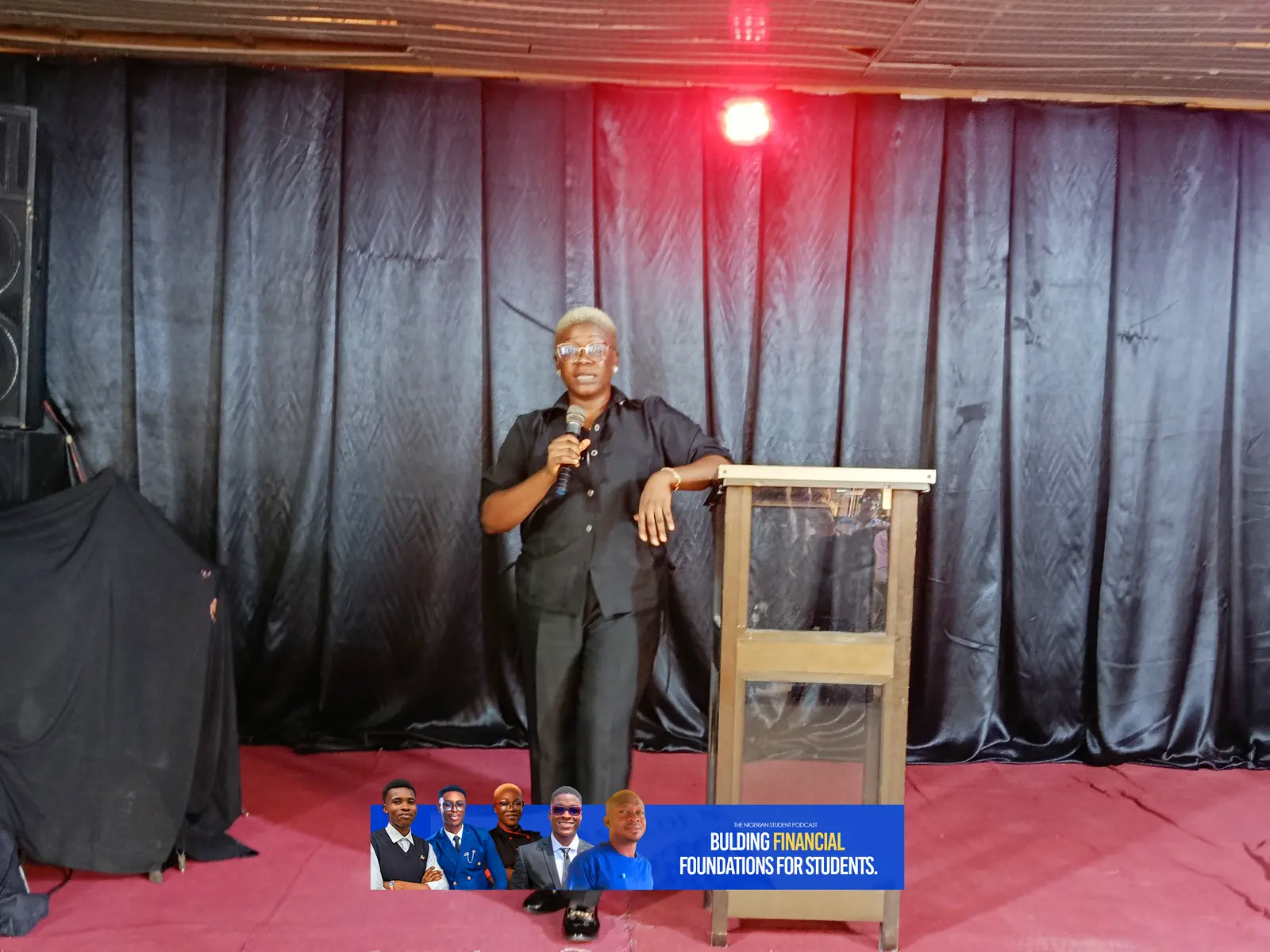 A speaker addresses the room from the stage
