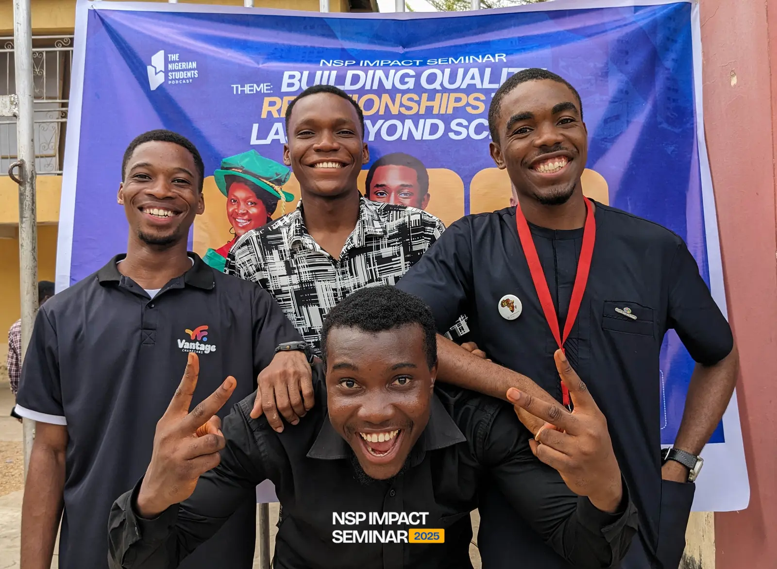 A group poses in front of the seminar banner